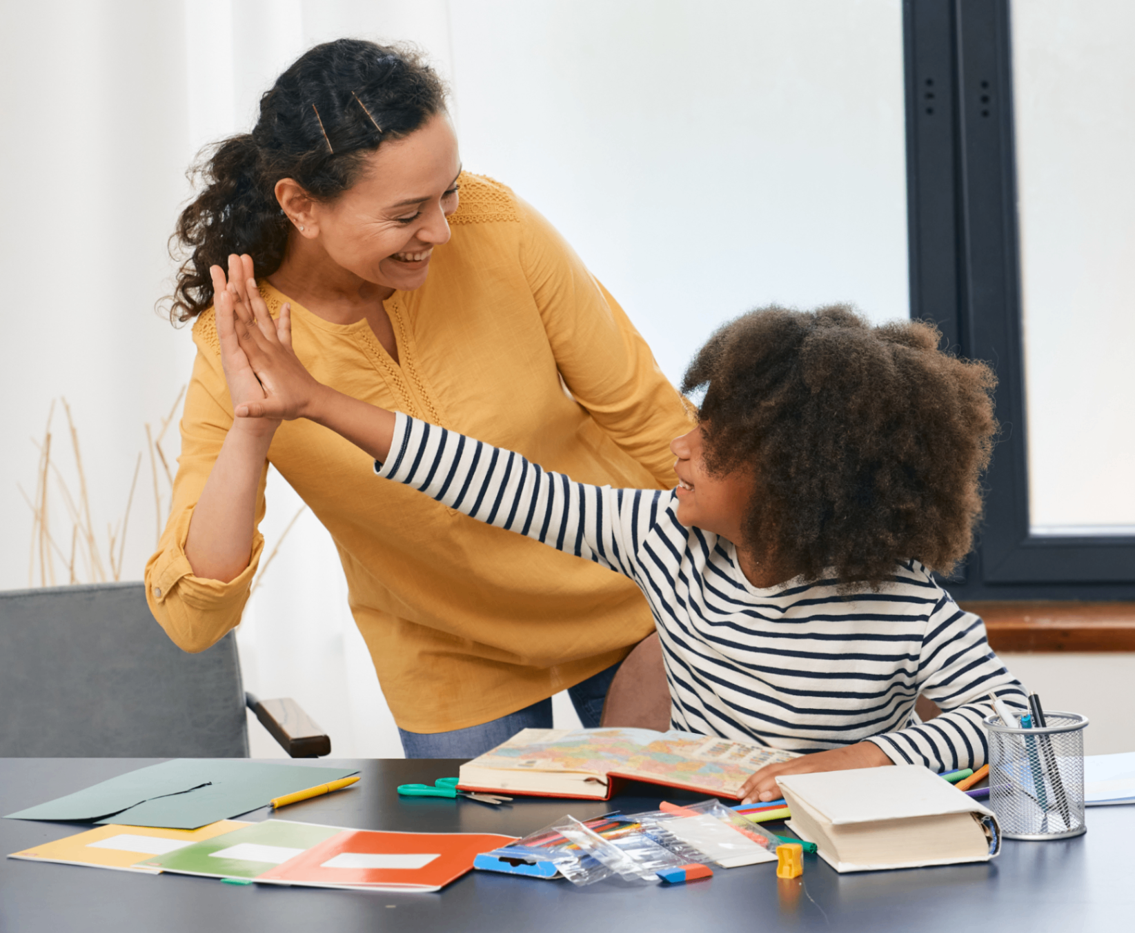 A caregiver and child smiling together during a learning activity.