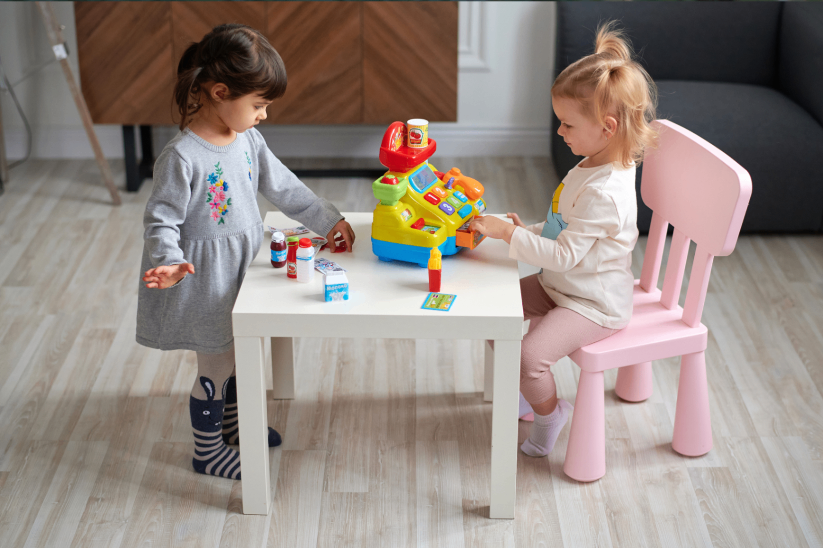 Two children playing safely at a small table indoors.