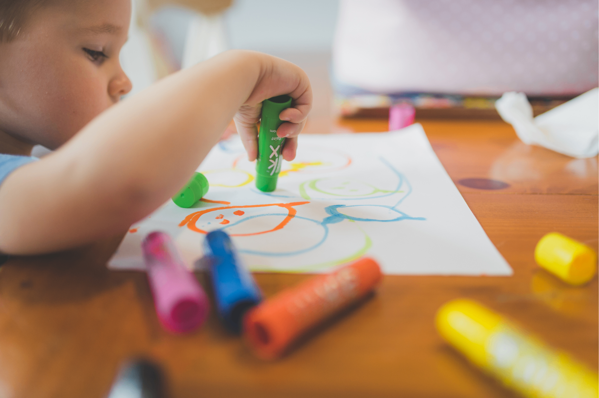 A child drawing with crayons during a quiet learning activity.